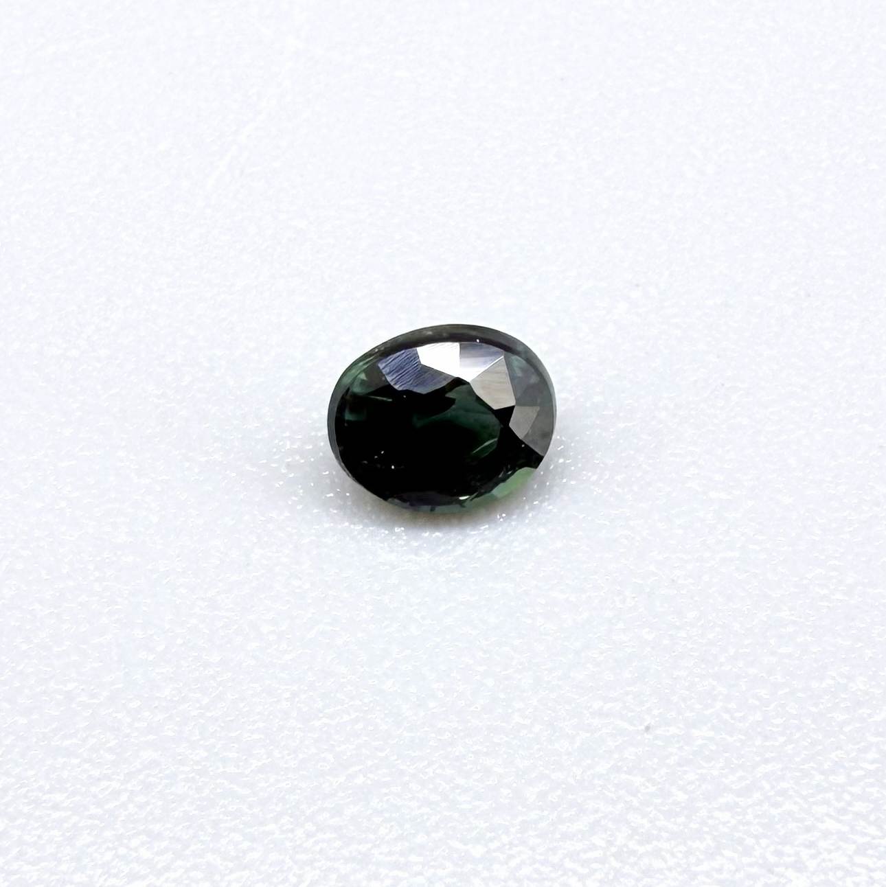 0.36 ct natural heated teal Laos sapphire with oval faceted cut and excellent clarity