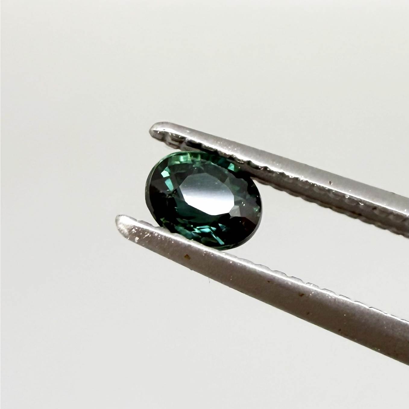 0.36 ct natural heated teal Laos sapphire with oval faceted cut and excellent clarity