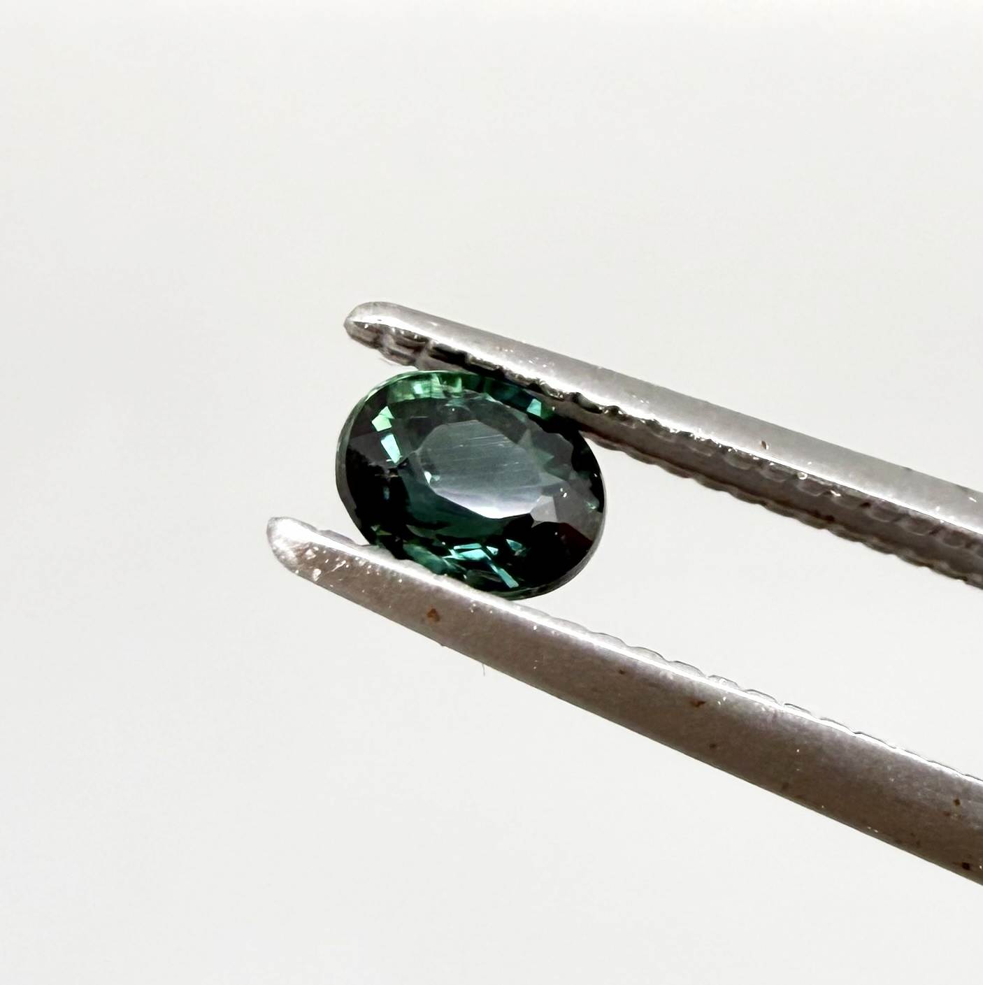 0.36 ct natural heated teal Laos sapphire with oval faceted cut and excellent clarity