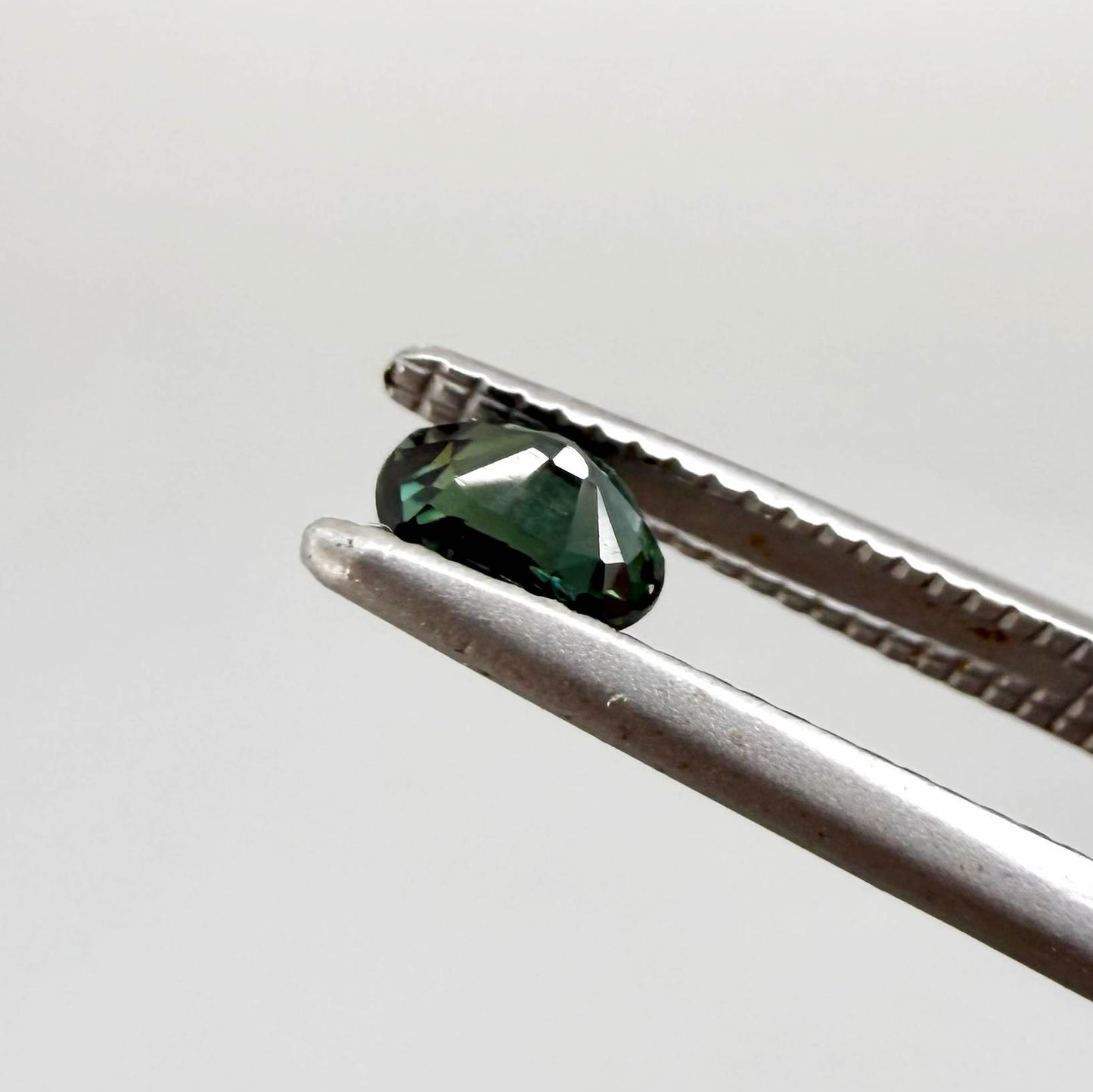 0.36 ct natural heated teal Laos sapphire with oval faceted cut and excellent clarity