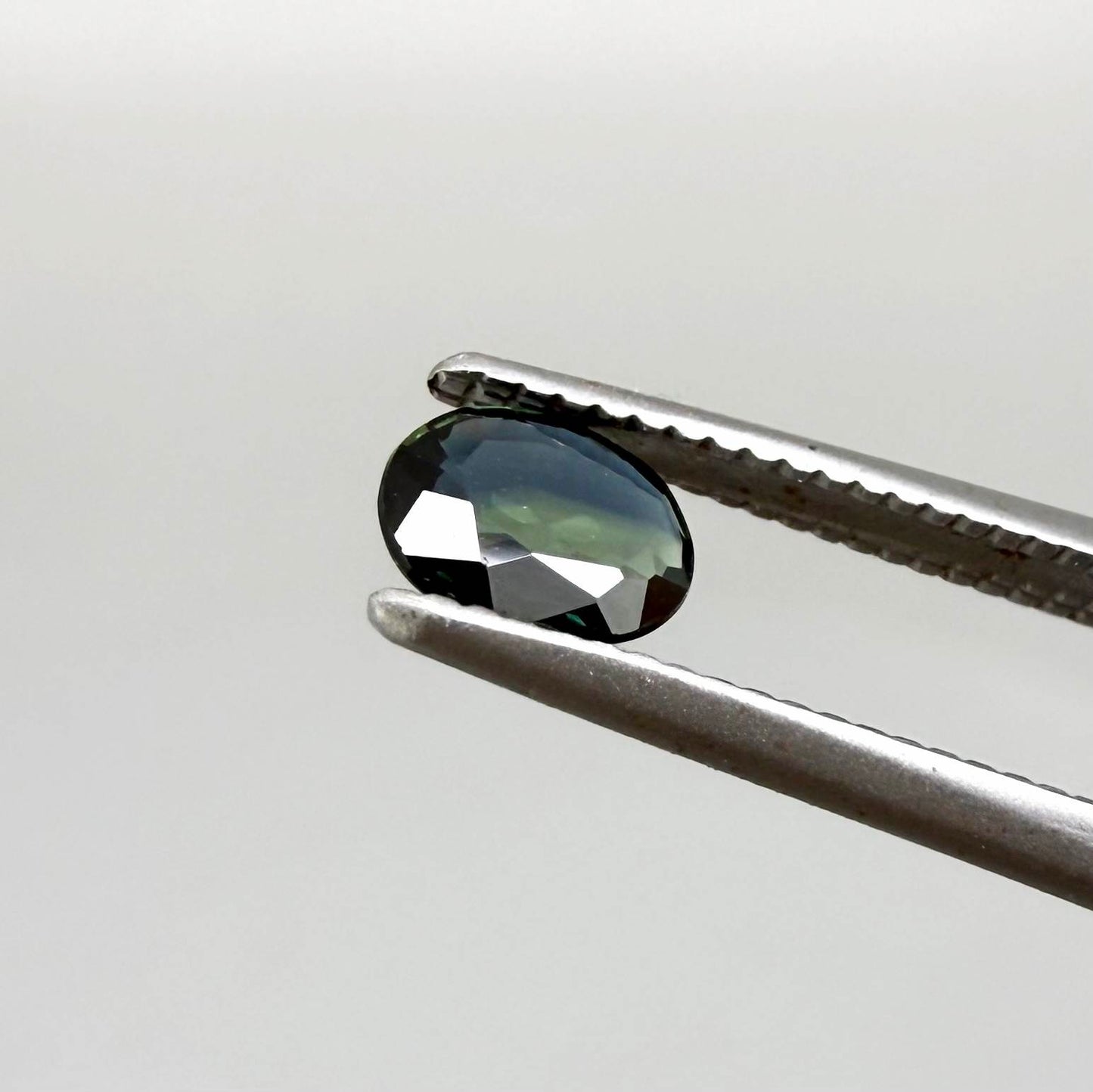0.28 ct natural parti teal Laos sapphire with oval faceted cut and blue green colour zoning
