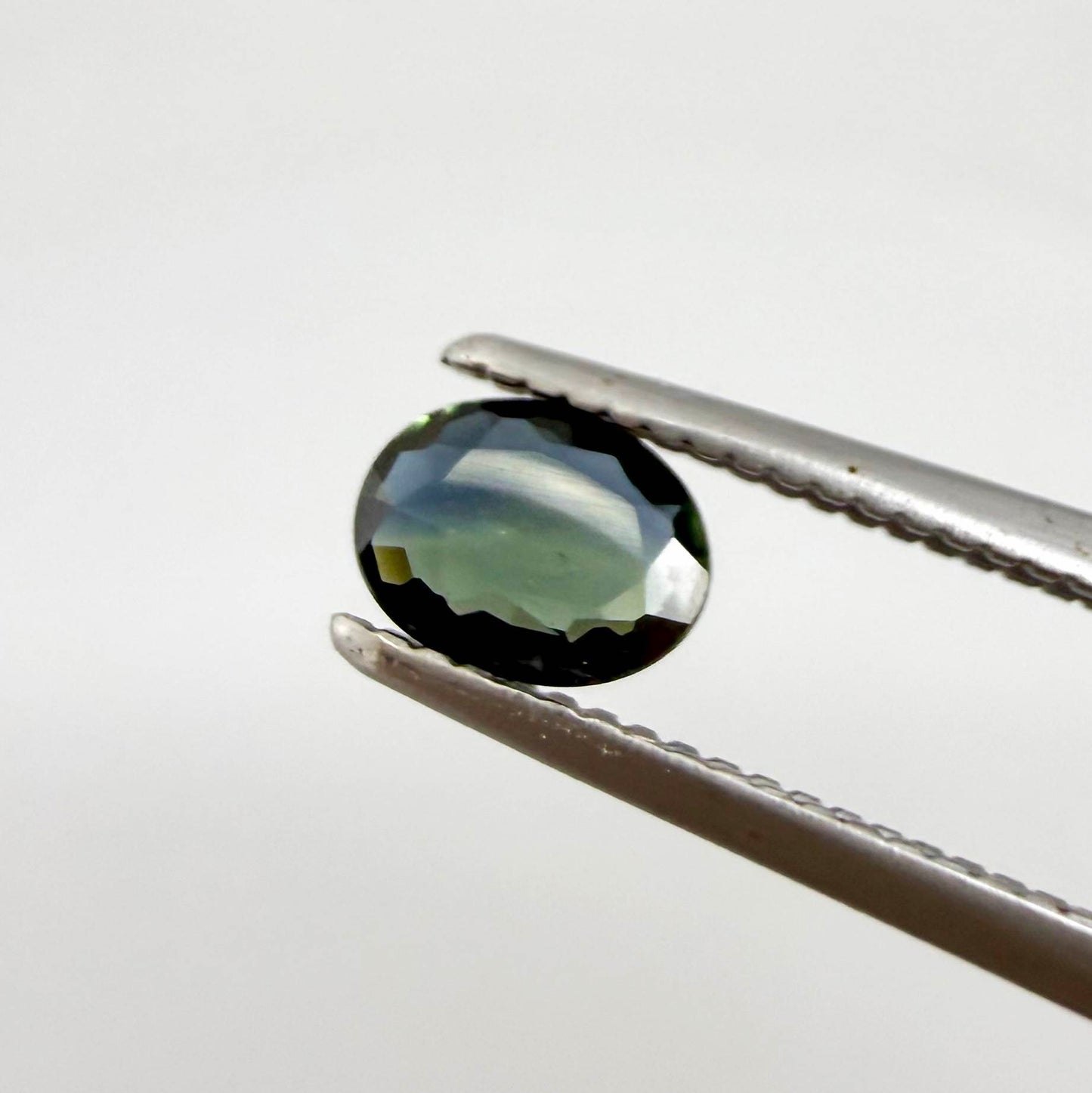 0.28 ct natural parti teal Laos sapphire with oval faceted cut and blue green colour zoning