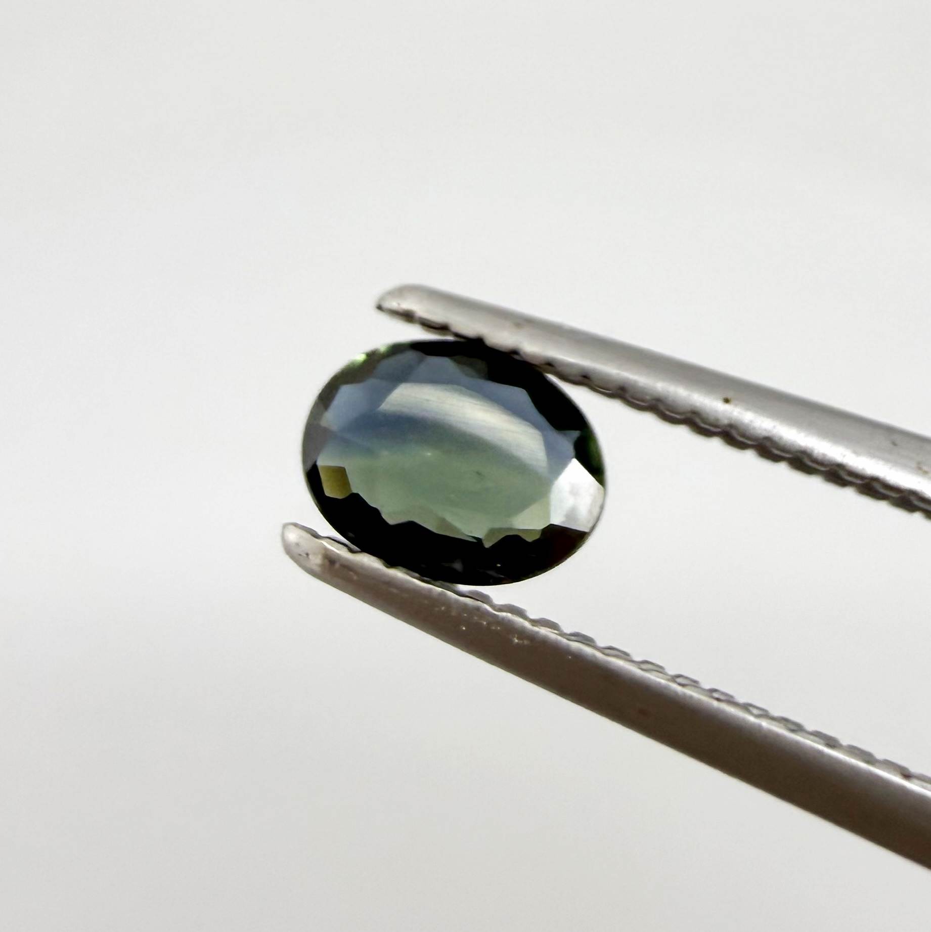 0.28 ct natural parti teal Laos sapphire with oval faceted cut and blue green colour zoning