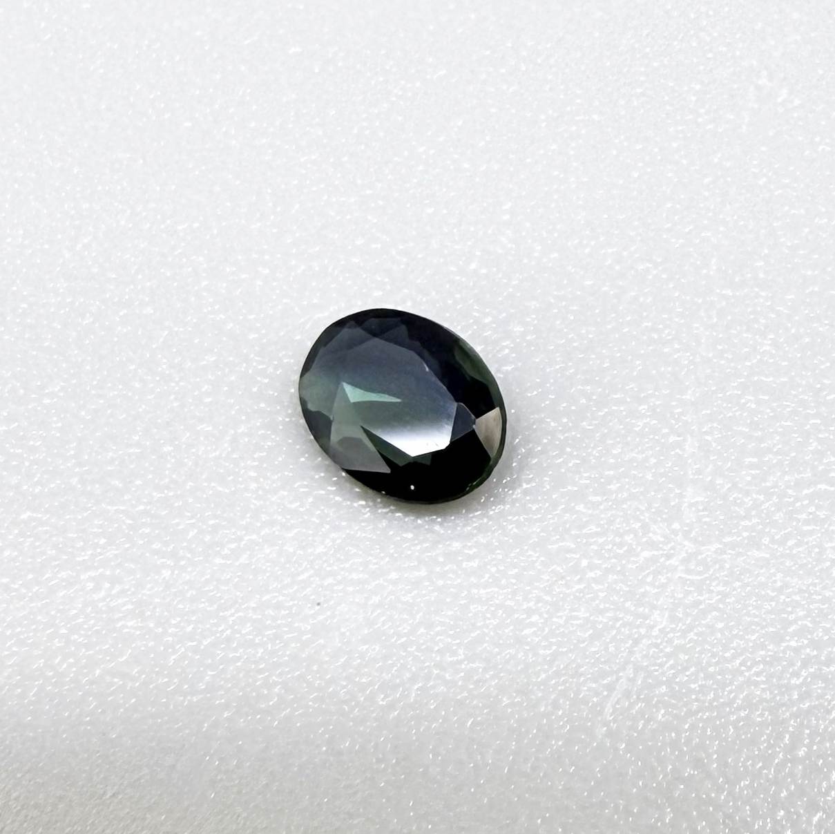 0.28 ct natural parti teal Laos sapphire with oval faceted cut and blue green colour zoning