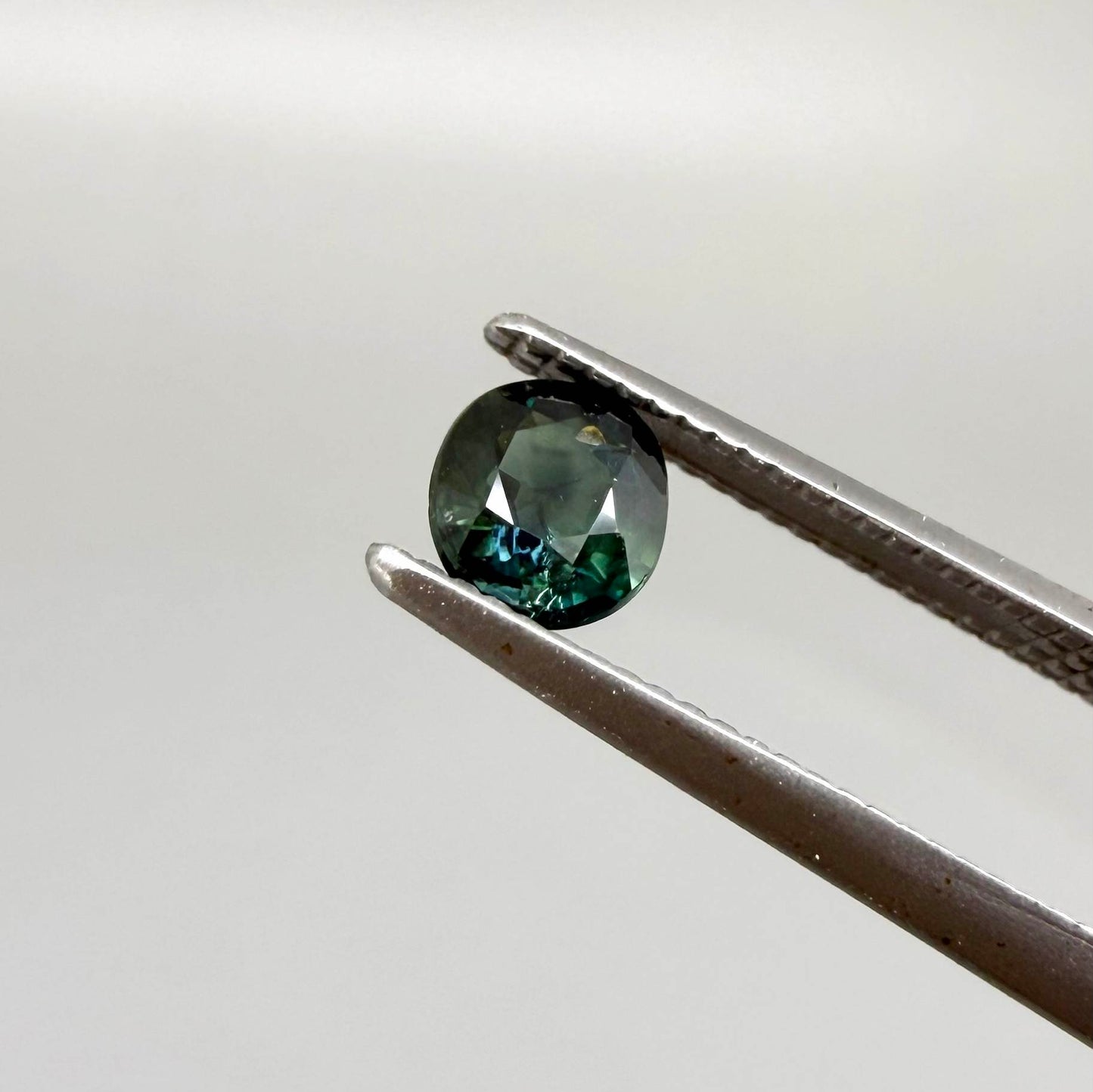 0.32 ct natural teal Laos sapphire with oval-cushion faceted cut and vibrant blue green colour