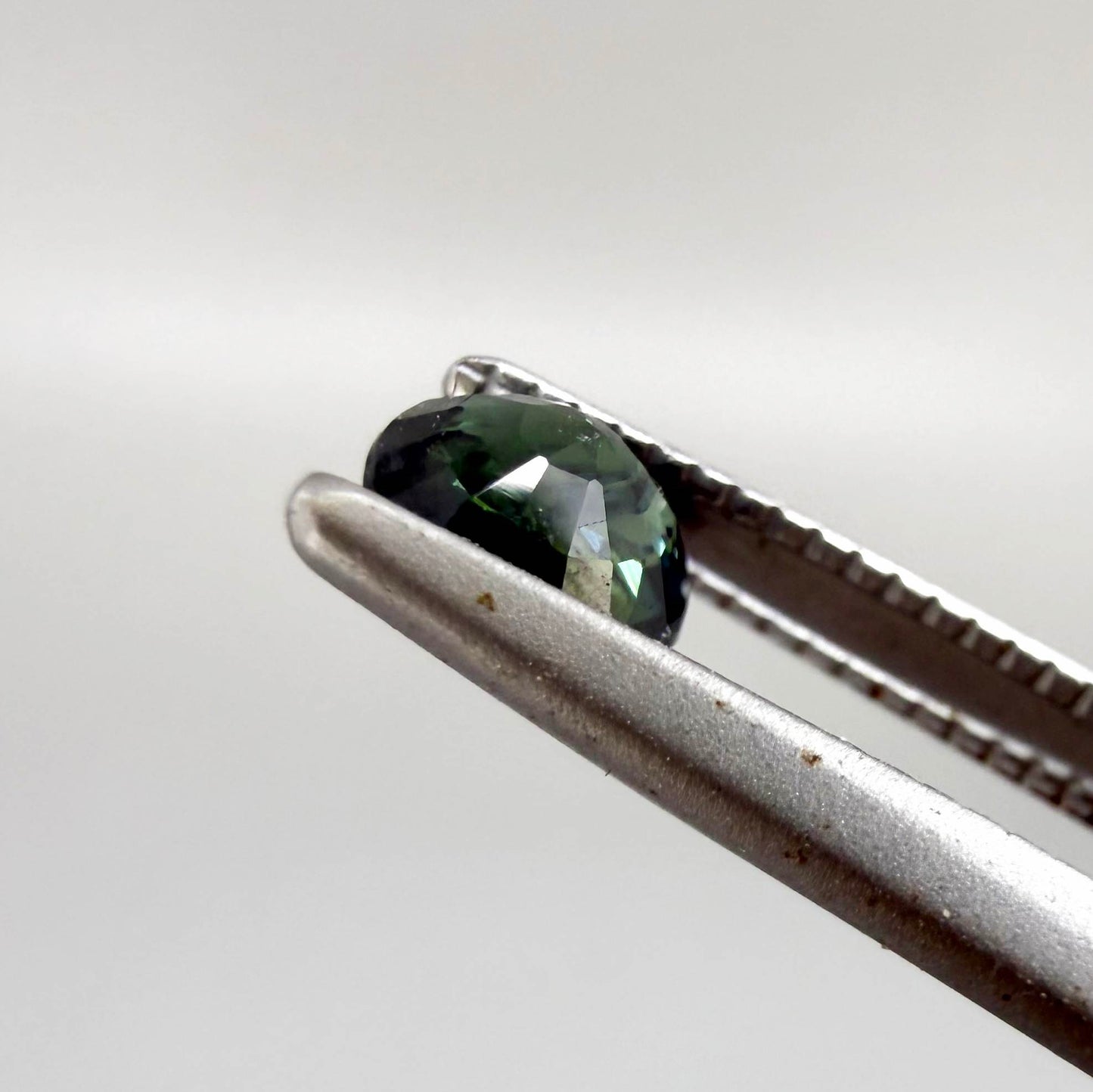0.32 ct natural teal Laos sapphire with oval-cushion faceted cut and vibrant blue green colour