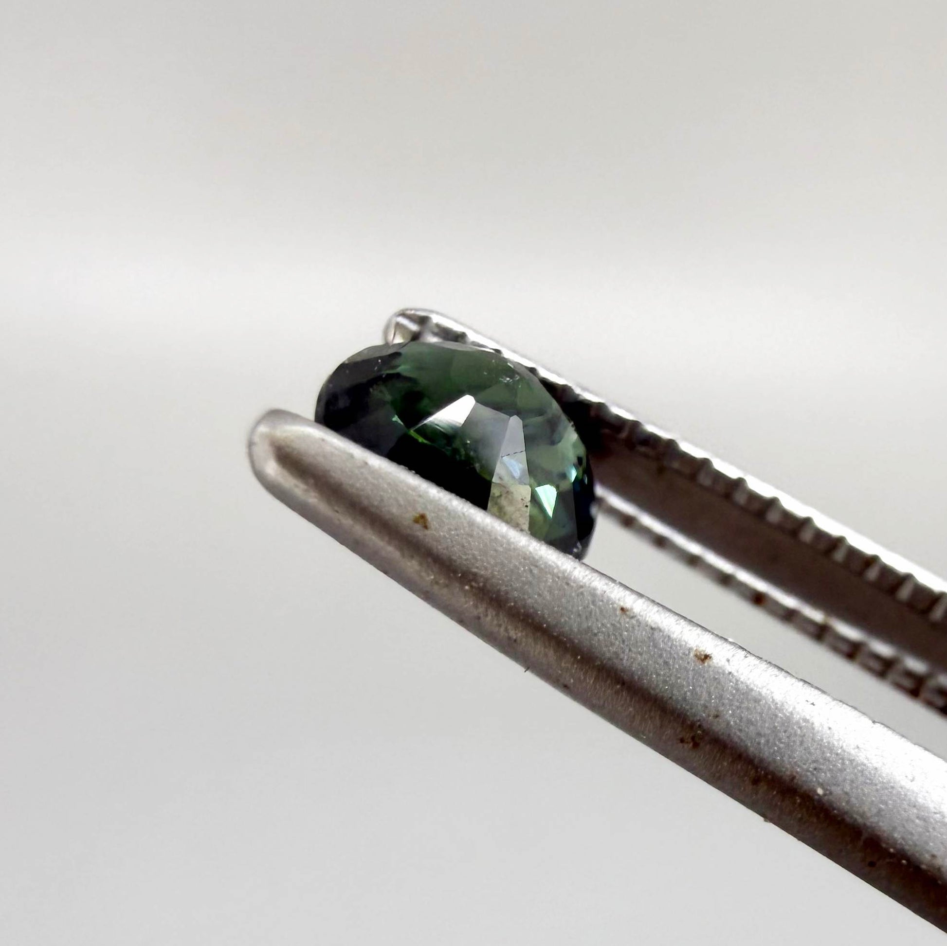 0.32 ct natural teal Laos sapphire with oval-cushion faceted cut and vibrant blue green colour