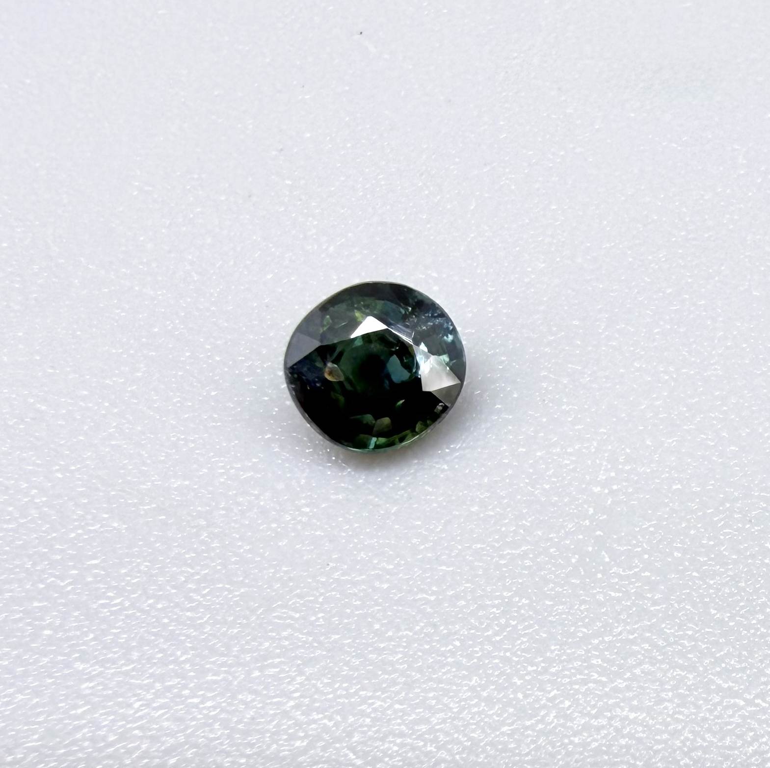 0.32 ct natural teal Laos sapphire with oval-cushion faceted cut and vibrant blue green colour