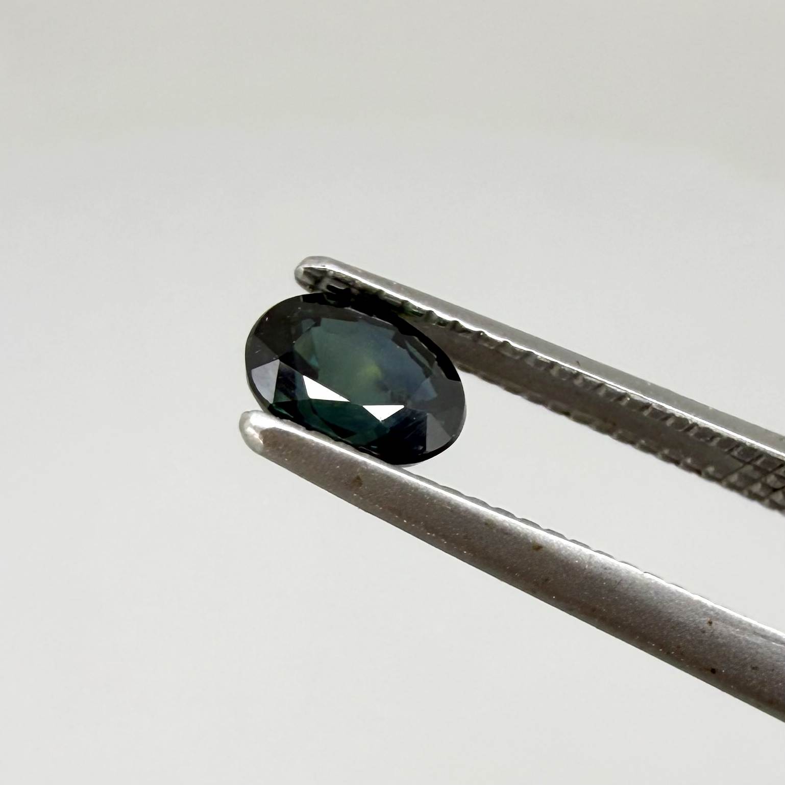 0.51 ct natural teal Laos sapphire with oval faceted cut and rich teal colour