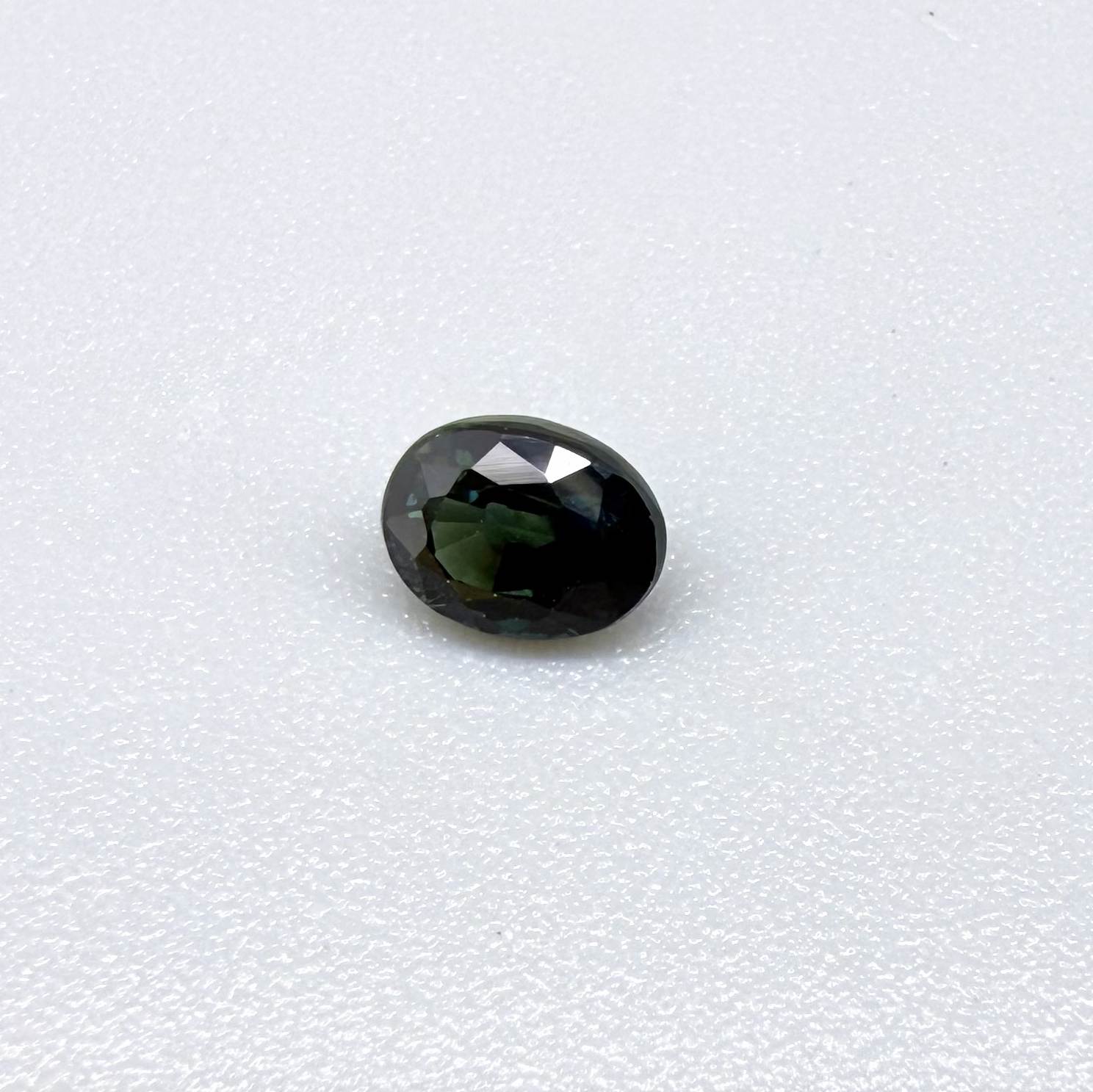 0.51 ct natural teal Laos sapphire with oval faceted cut and rich teal colour