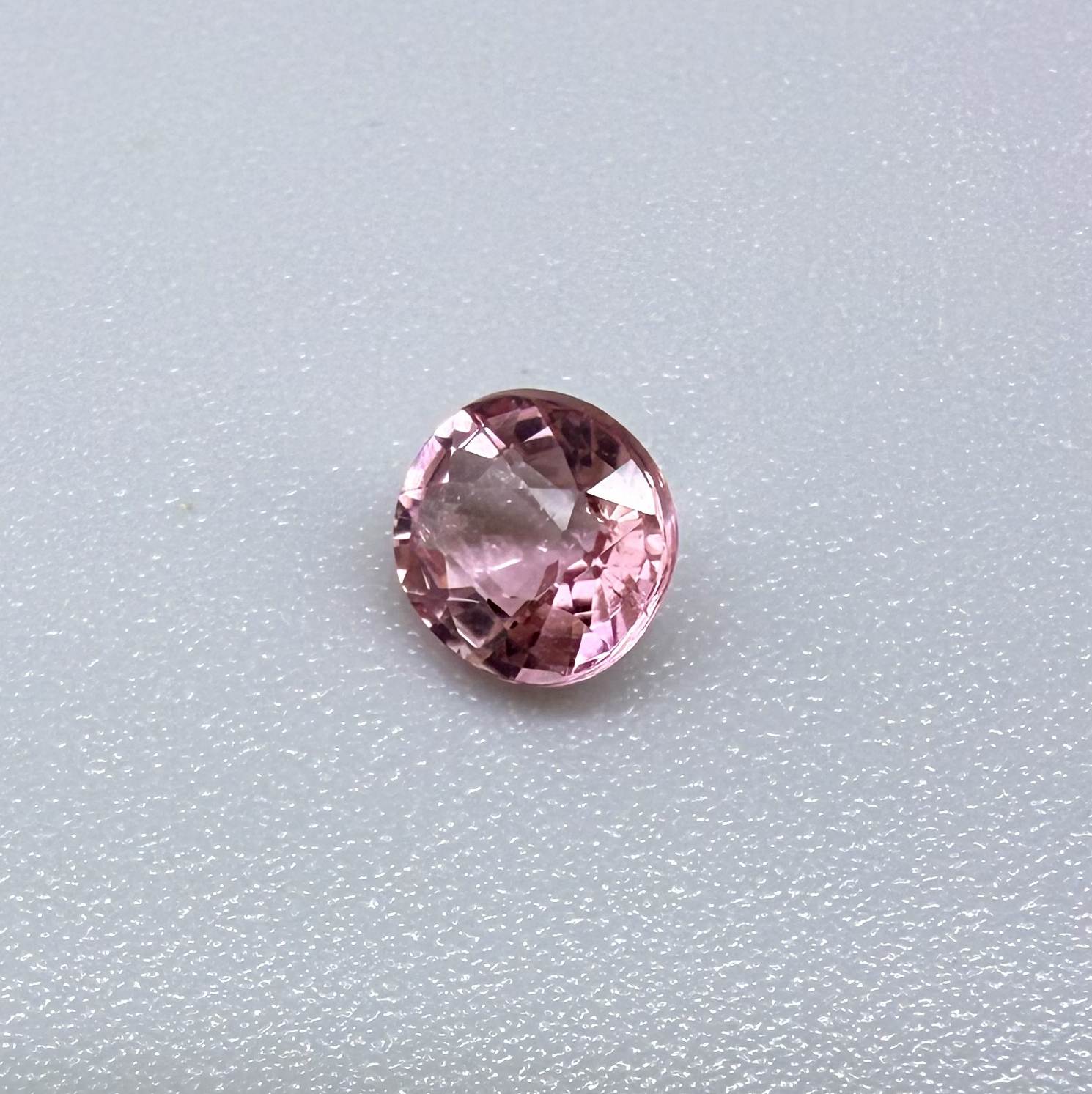 Natural untreated pink tourmaline, 0.57 ct round cut from Nigeria, eye-clean with bright pink colour and excellent brilliance.