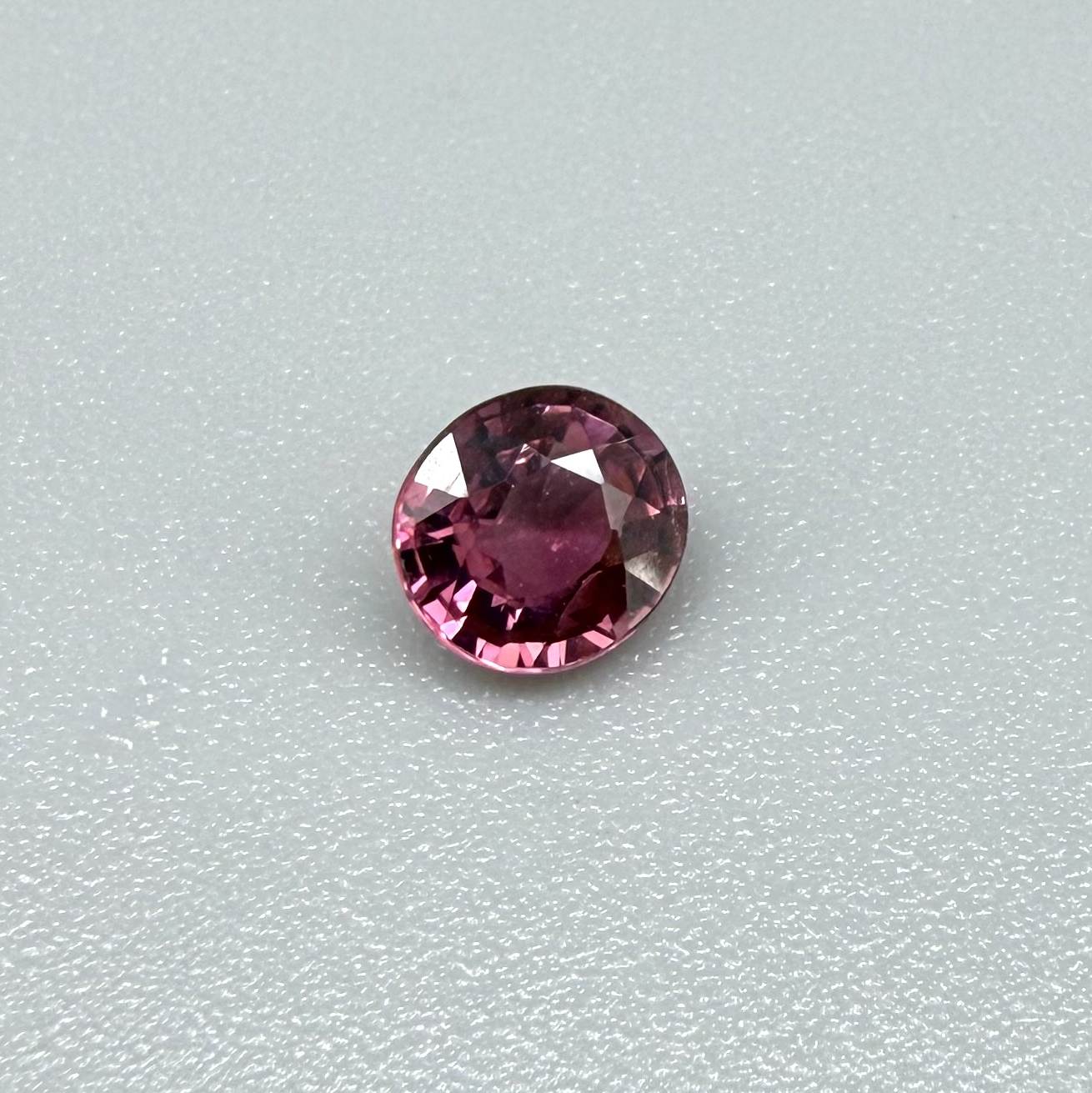 Natural untreated vivid raspberry pink tourmaline, 0.56 ct round cut from Nigeria with vivid raspberry pink colour, eye-clean clarity and exceptional brilliance.