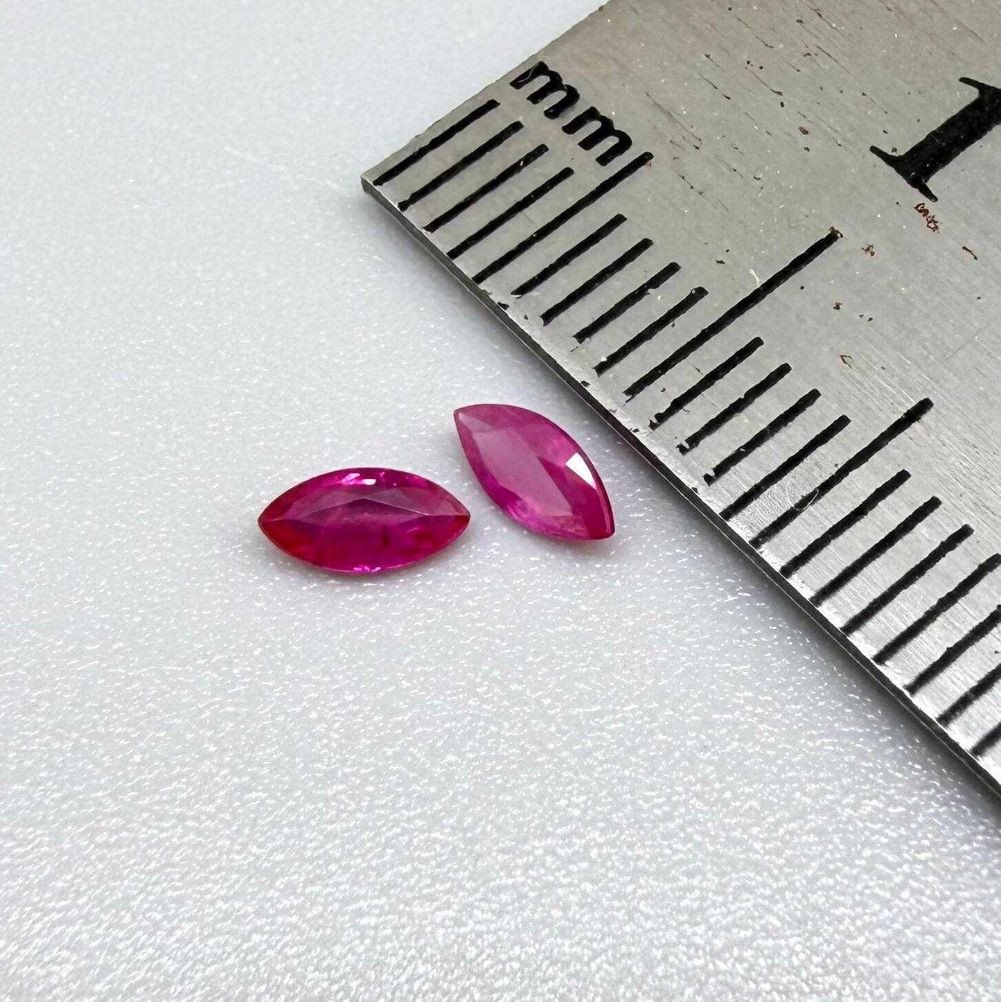 Faceted marquise-cut pinkish-red ruby pair with a total weight of 0.34 ct, eye-clean appearance with natural inclusions