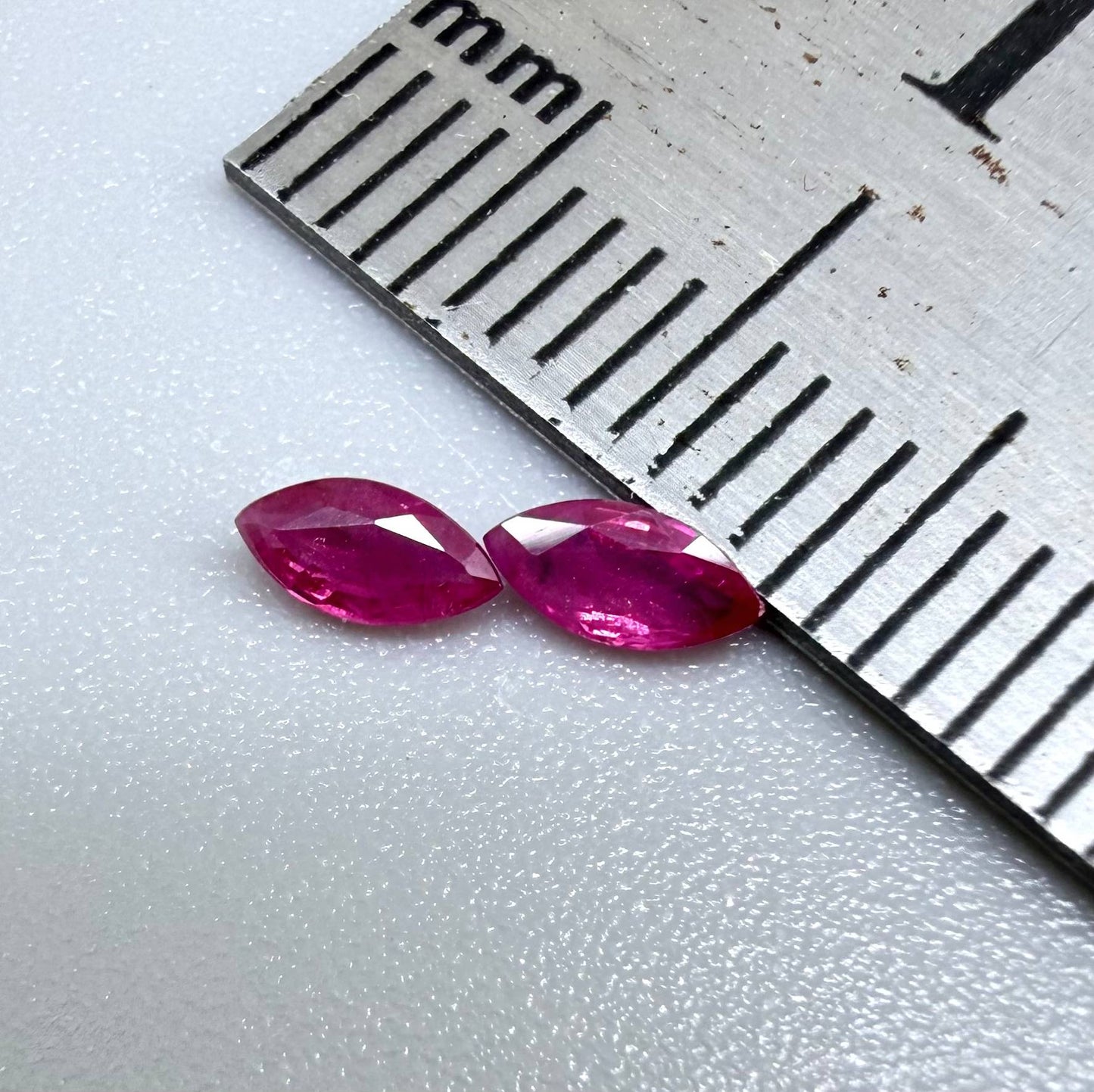 Two reddish-pink marquise-cut rubies, with a total of 0.33 ct, eye-clean appearance with fine natural inclusions