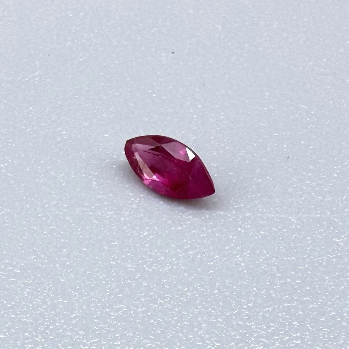 A marquise-cut pink-red ruby from Myanmar, 0.18 ct with eye-clean to slightly silky appearance