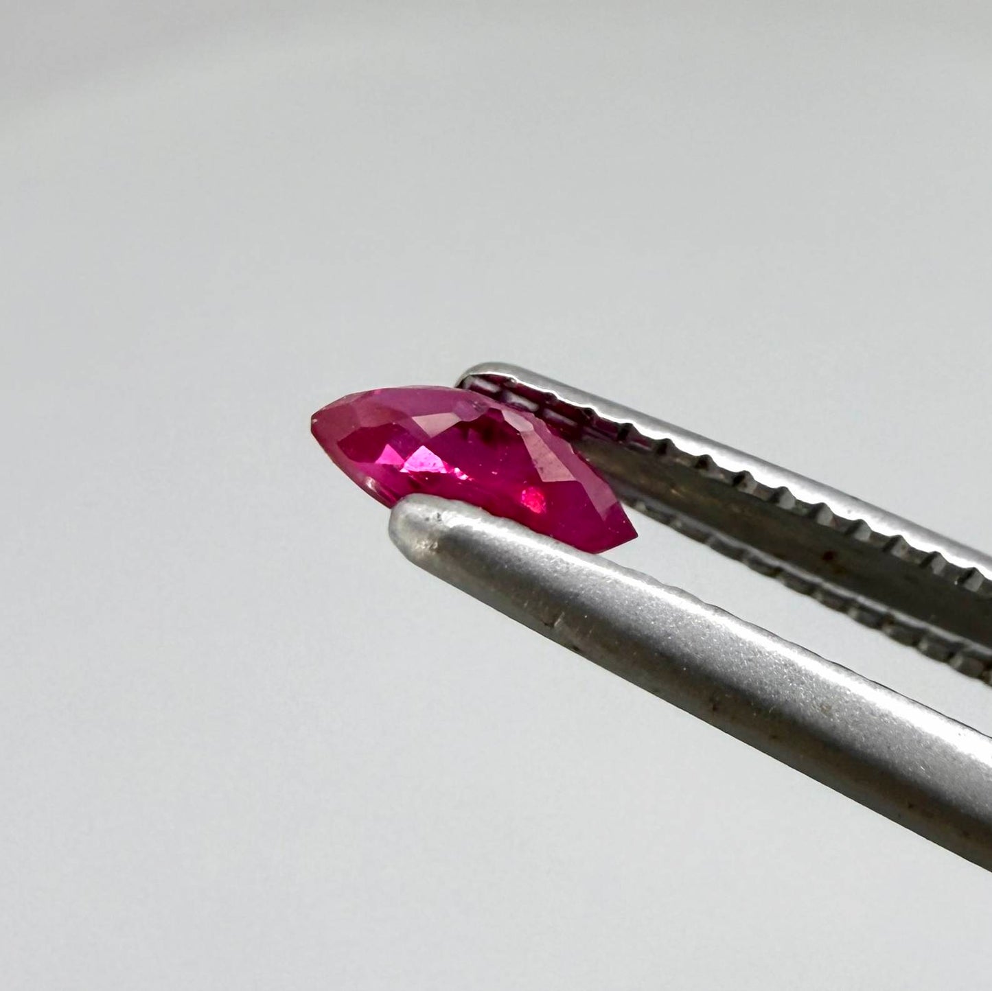 A marquise-cut pink-red ruby from Myanmar, 0.18 ct with eye-clean to slightly silky appearance