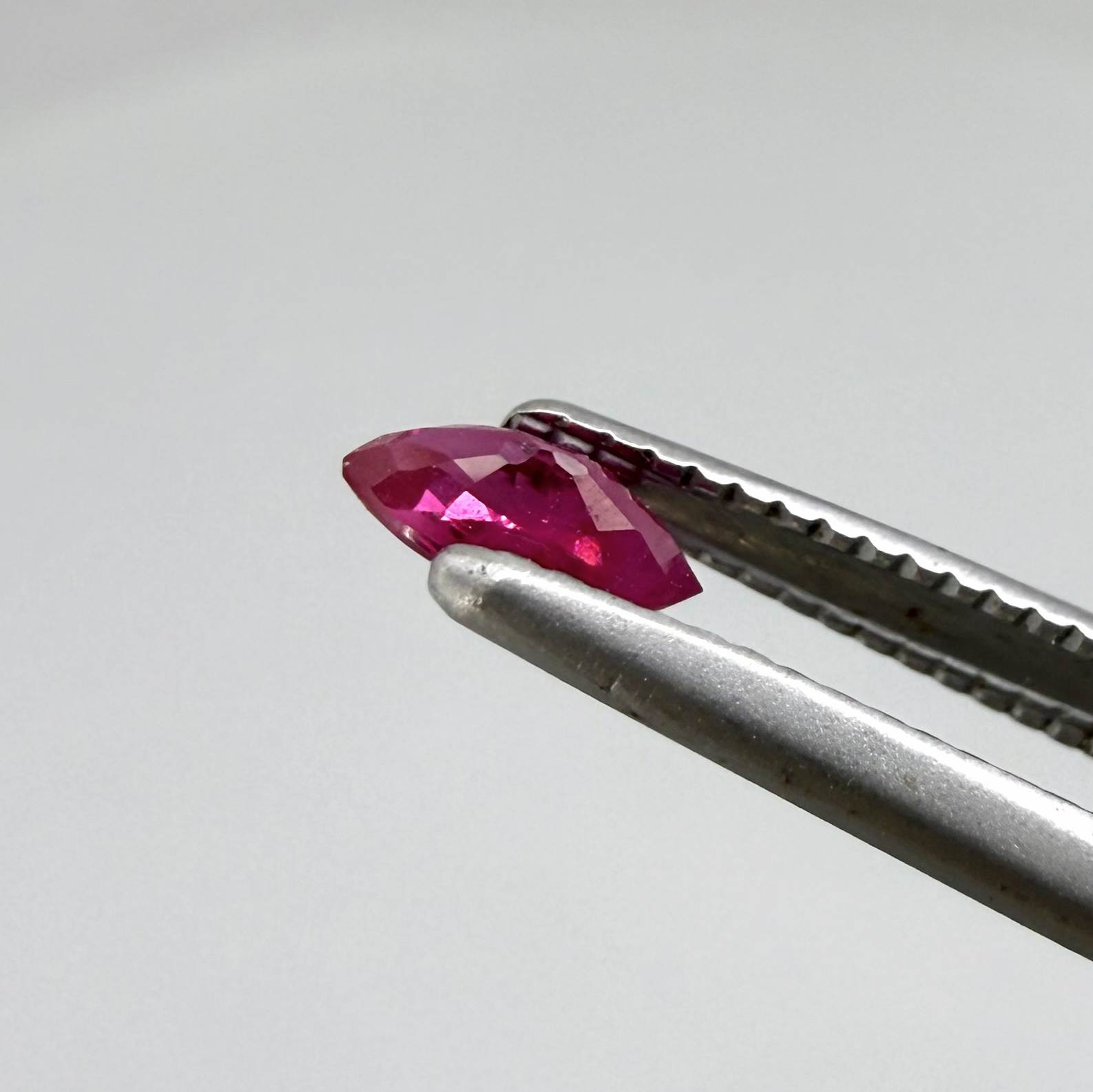 A marquise-cut pink-red ruby from Myanmar, 0.18 ct with eye-clean to slightly silky appearance