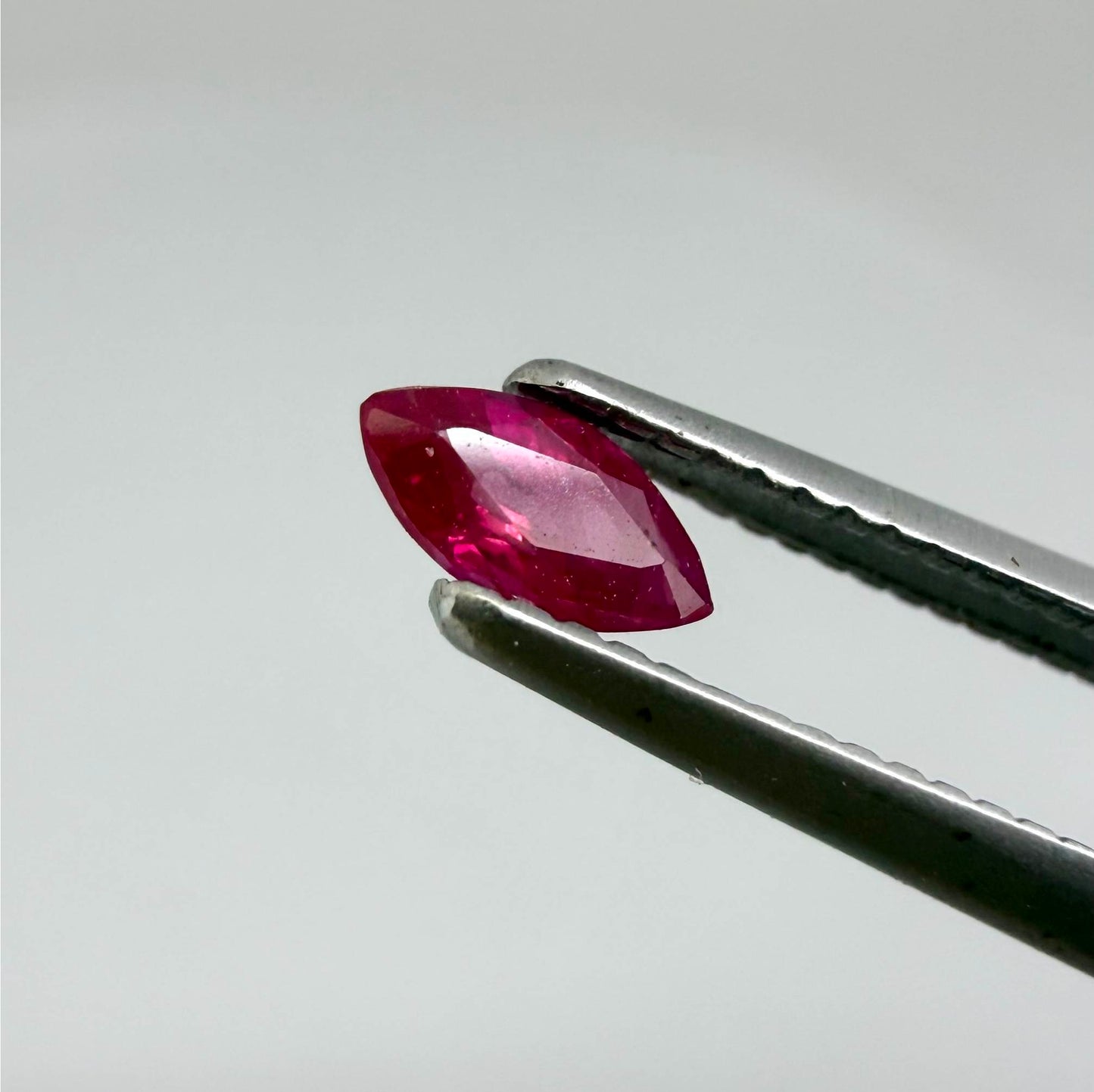 A marquise-cut pink-red ruby from Myanmar, 0.18 ct with eye-clean to slightly silky appearance