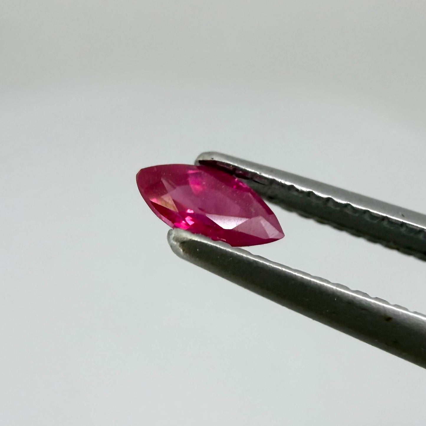 A marquise-cut pink-red ruby from Myanmar, 0.18 ct with eye-clean to slightly silky appearance