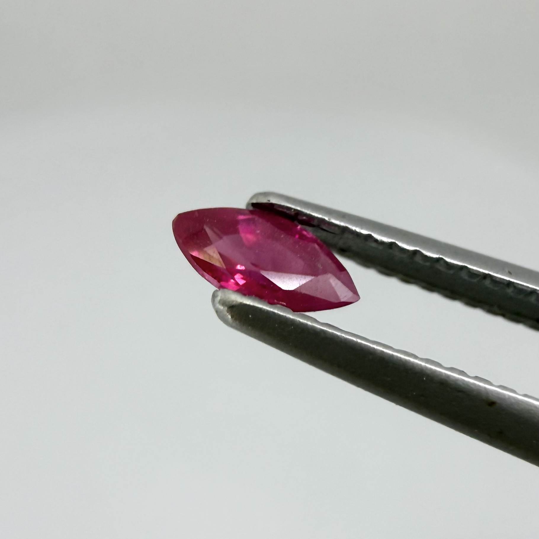A marquise-cut pink-red ruby from Myanmar, 0.18 ct with eye-clean to slightly silky appearance