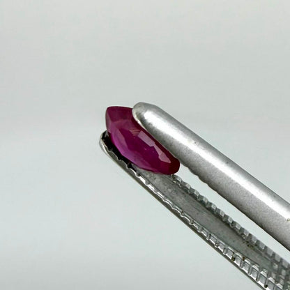 A faceted marquise-cut ruby with deep magenta-red coloration, 0.18 ct of weight with slightly silky appearance and fine natural inclusions