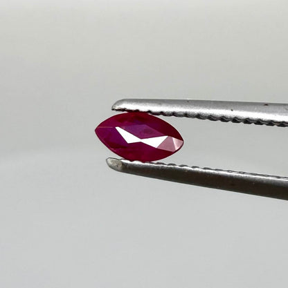 A faceted marquise-cut ruby with deep magenta-red coloration, 0.18 ct of weight with slightly silky appearance and fine natural inclusions