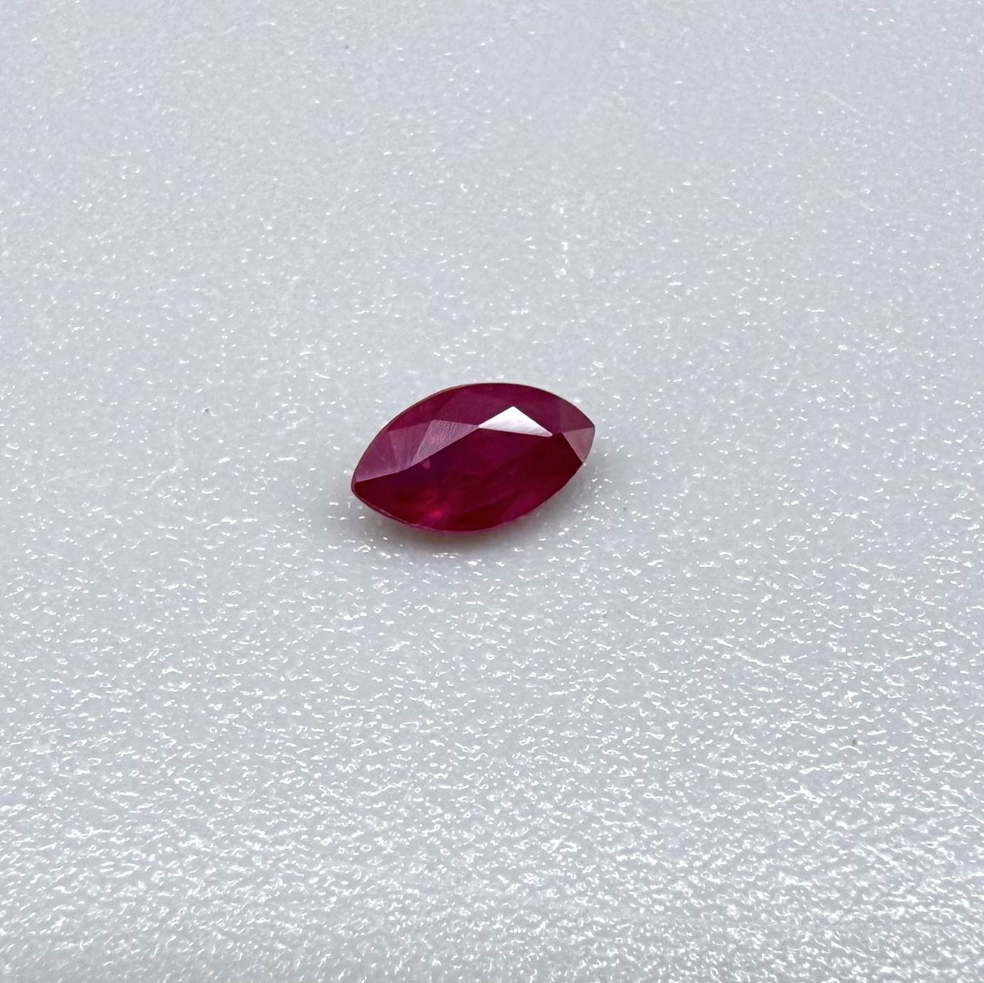 A faceted marquise-cut ruby with deep magenta-red coloration, 0.18 ct of weight with slightly silky appearance and fine natural inclusions