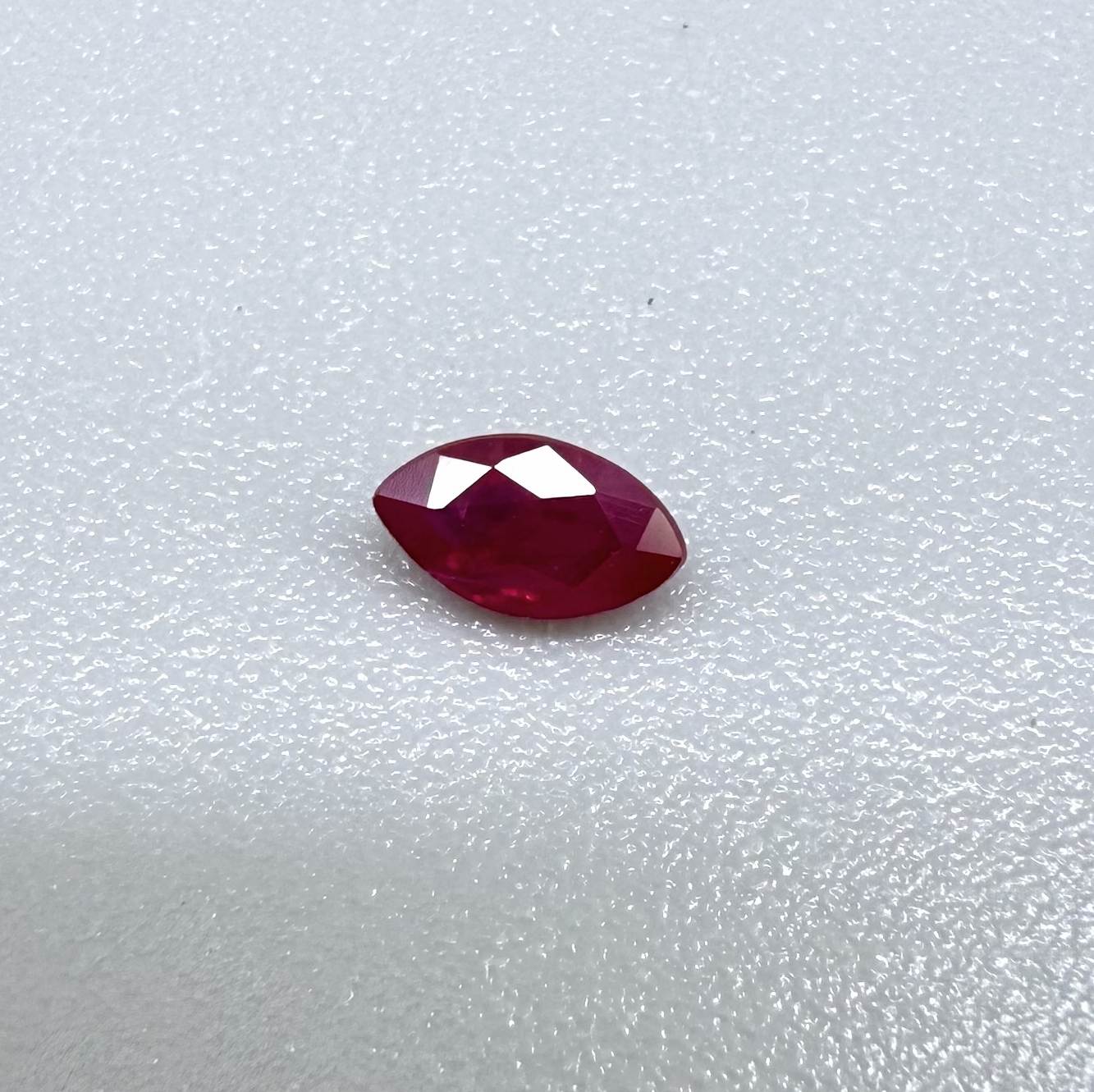 A faceted marquise-cut ruby with deep magenta-red coloration, 0.18 ct of weight with slightly silky appearance and fine natural inclusions
