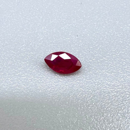 A faceted marquise-cut ruby with deep magenta-red coloration, 0.18 ct of weight with slightly silky appearance and fine natural inclusions