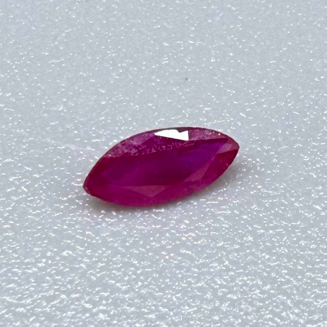 A marquise-cut ruby with a deep magenta-red hue, 0.17 ct of weight with slightly silky appearance and natural inclusions