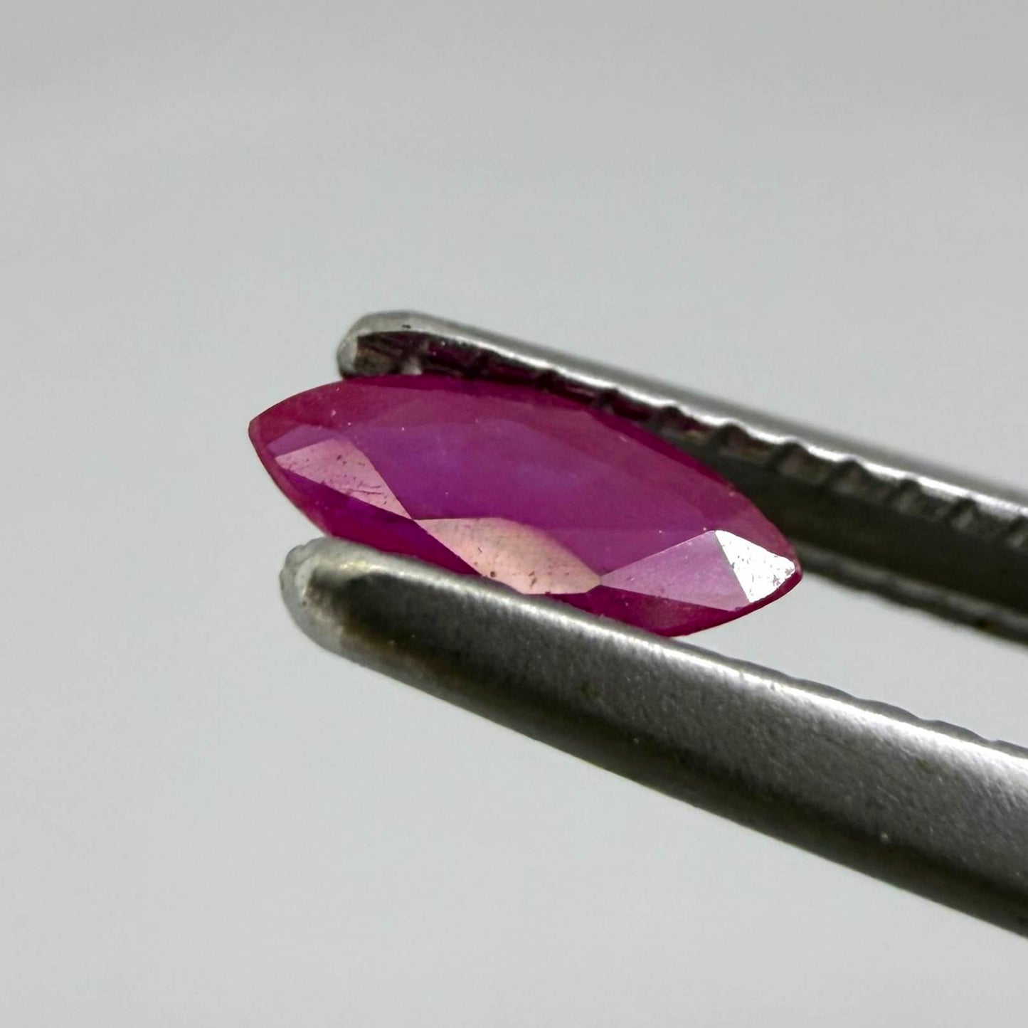 A marquise-cut ruby with a deep magenta-red hue, 0.17 ct of weight with slightly silky appearance and natural inclusions