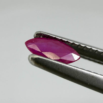 A marquise-cut ruby with a deep magenta-red hue, 0.17 ct of weight with slightly silky appearance and natural inclusions