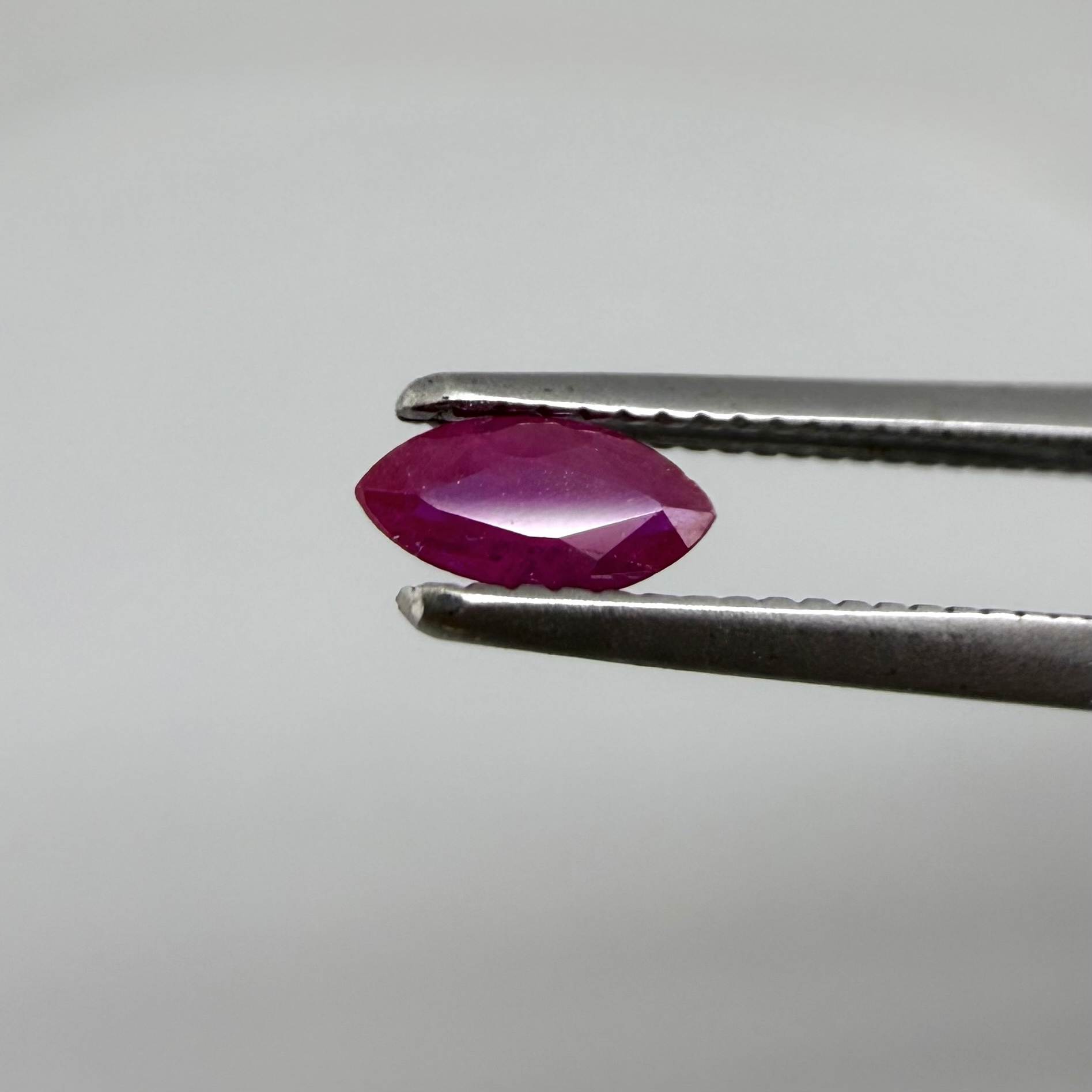 A marquise-cut ruby with a deep magenta-red hue, 0.17 ct of weight with slightly silky appearance and natural inclusions