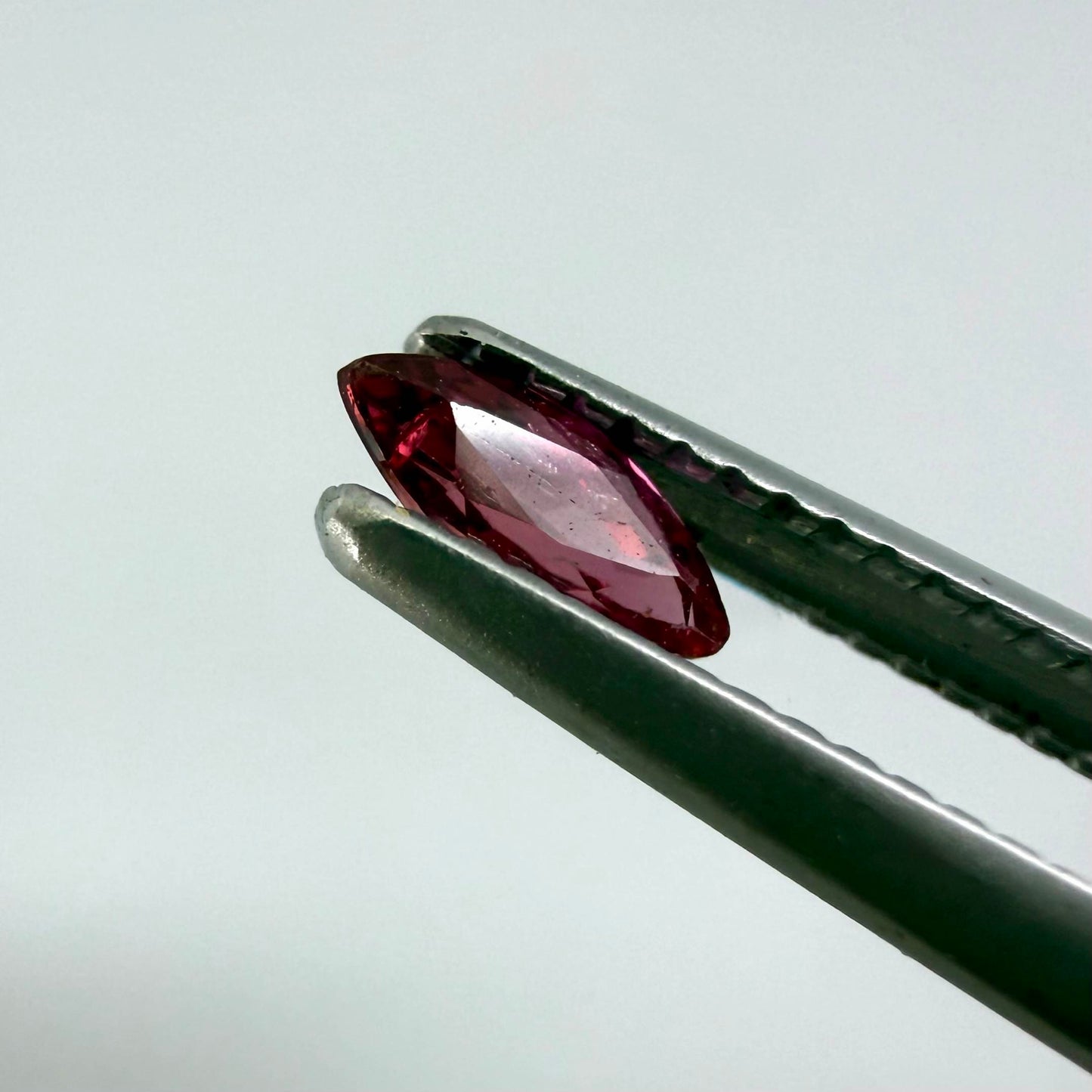 A marquise-cut deep pinkish-red ruby from Myanmar, 0.17 ct with eye-clean appearance and with fine natural inclusions