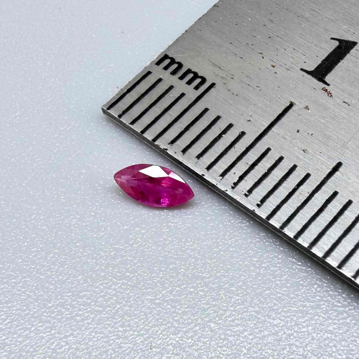 A small marquise-cut pink ruby from Myanmar, 0.16 ct, eye-clean appearance with fine natural inclusions