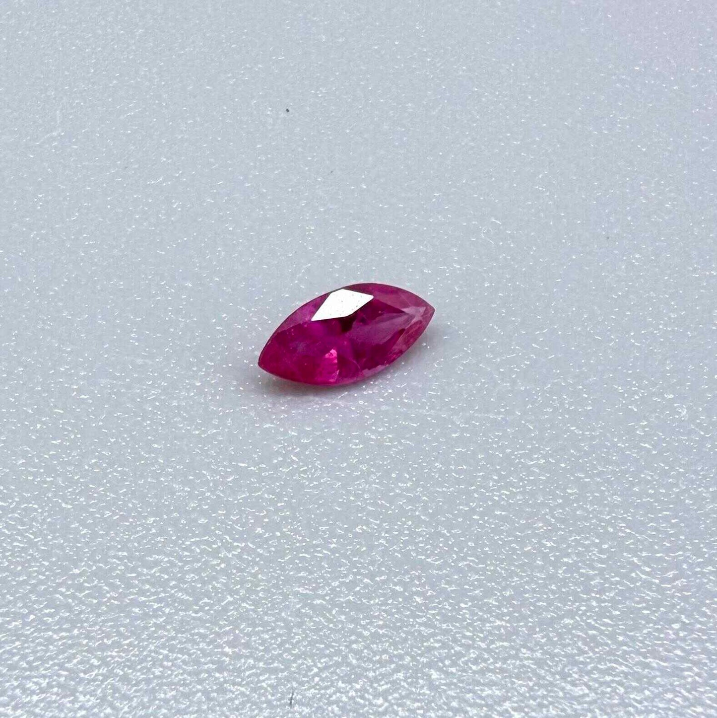 A small marquise-cut pink ruby from Myanmar, 0.16 ct, eye-clean appearance with fine natural inclusions