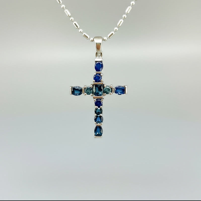 Handcrafted cross pendant with blue sapphires set in white-gold-plated sterling silver.
