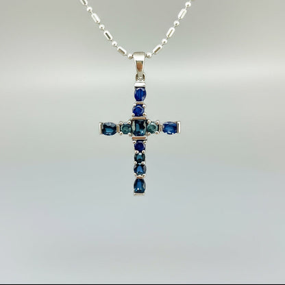 Handcrafted cross pendant with blue sapphires set in white-gold-plated sterling silver.