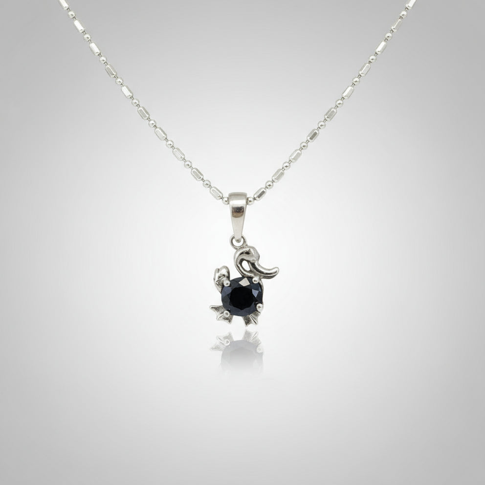 White-gold-plated silver pendant shaped like a duck with a natural sapphire body.