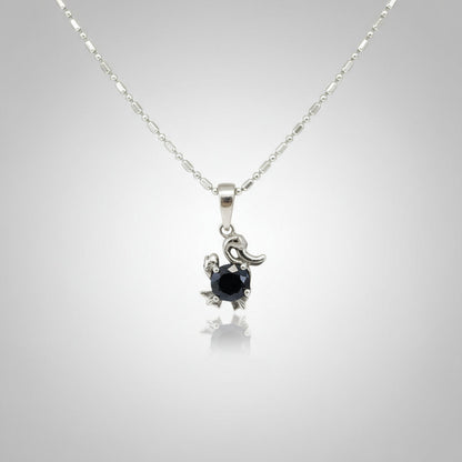 White-gold-plated silver pendant shaped like a duck with a natural sapphire body.
