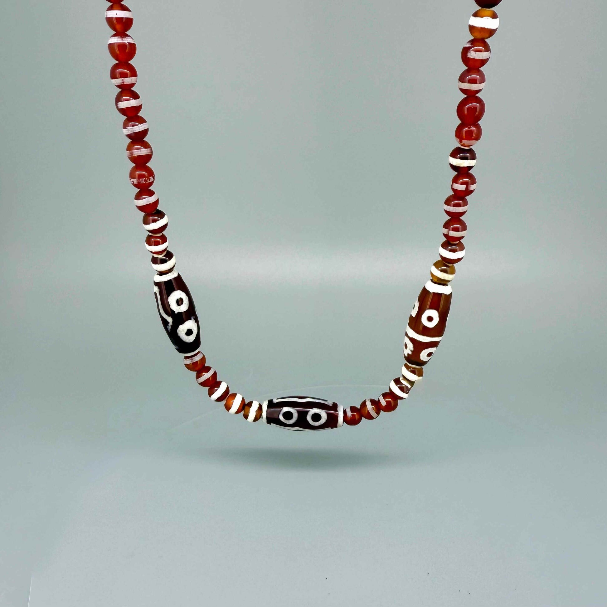 Handcrafted agate necklace with reddish-brown beads and patterned focal bead, 50 cm.
