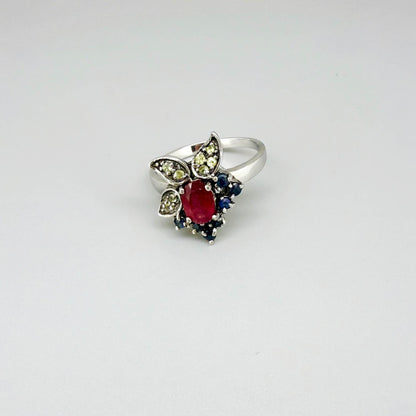 Sterling silver ring featuring a natural ruby at the center, accented by sapphires and peridot in a colorful gemstone cluster design.