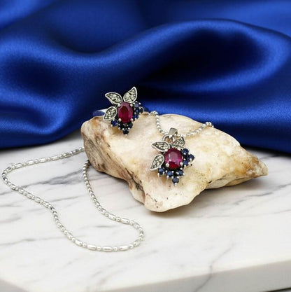 Sterling silver ring featuring a natural ruby at the center, accented by sapphires and peridot in a colorful gemstone cluster design.