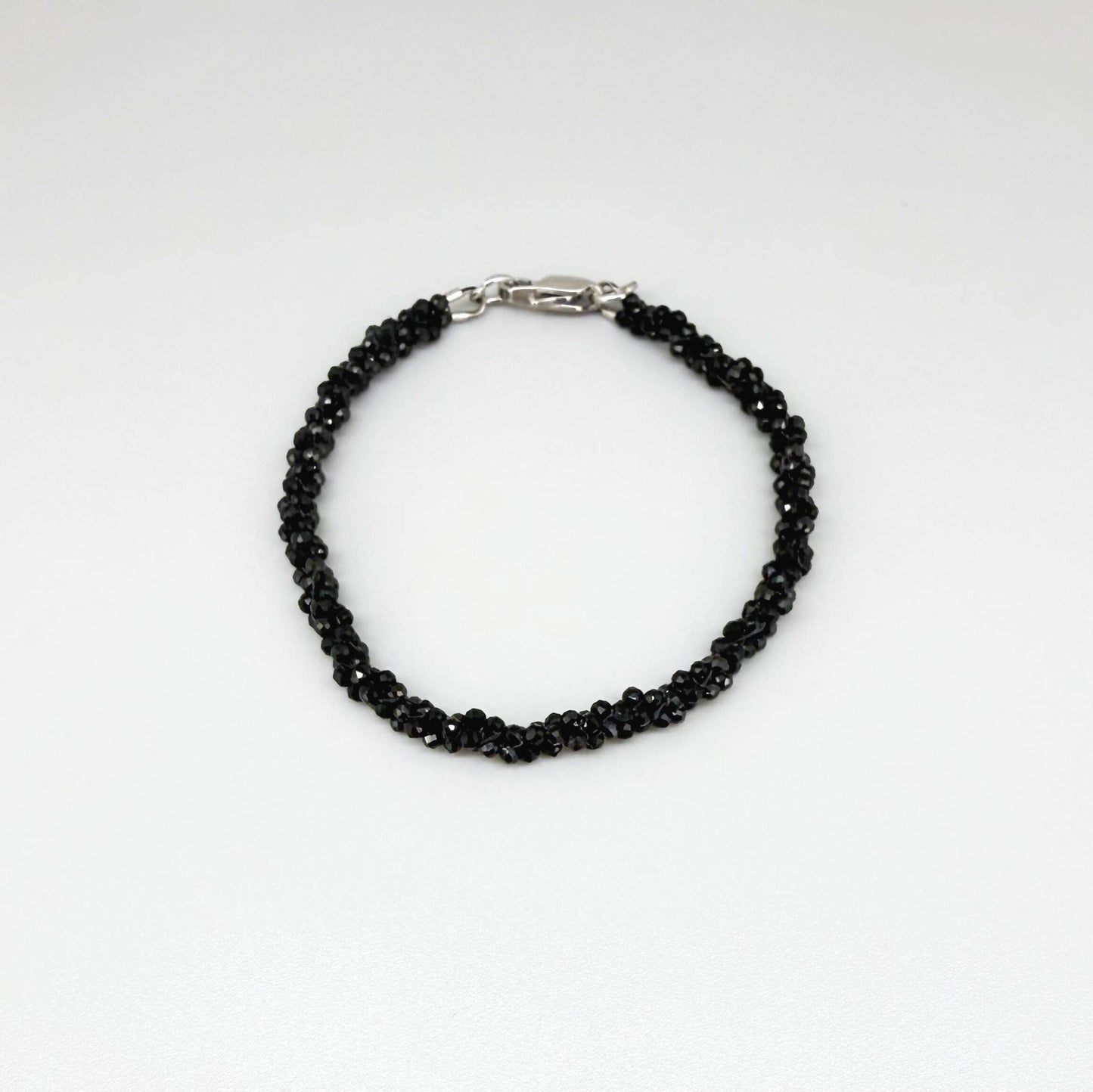 18 cm bracelet with faceted round black spinel beads, finished with a lobster clasp.