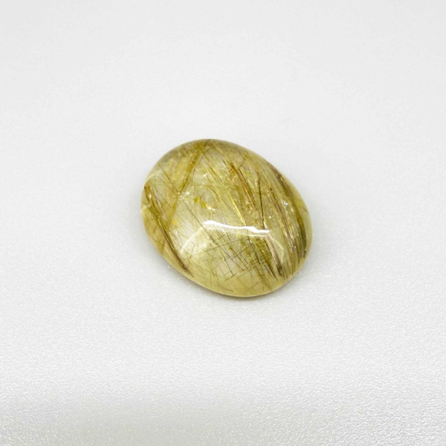 23.3 ct natural Rutilated Quartz with golden rutile inclusions, faceted cut, transparent body and visible needle patterns.