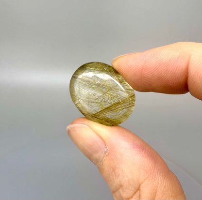 23.3 ct natural Rutilated Quartz with golden rutile inclusions, faceted cut, transparent body and visible needle patterns.