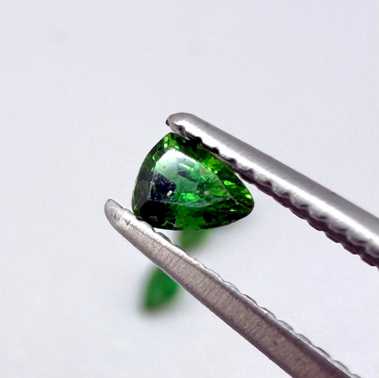 Small lot of four natural vibrant-green diopside stones, trillion cut, total 0.54 ct.