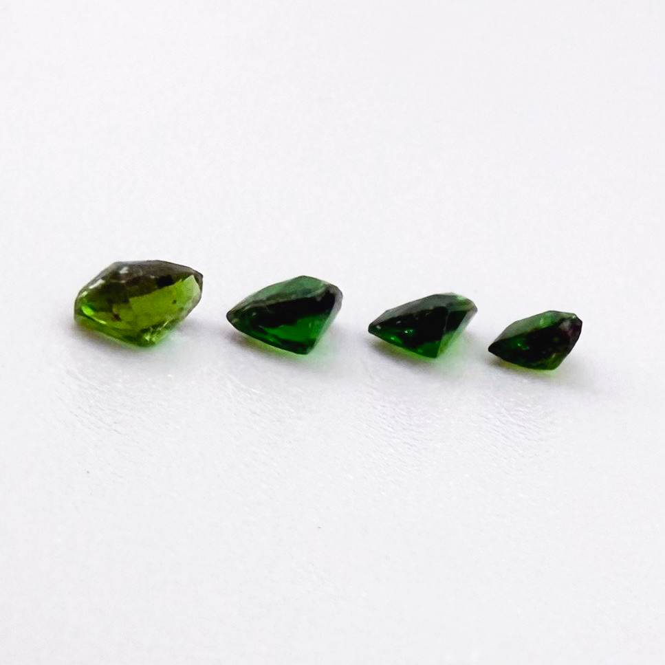 Small lot of four natural vibrant-green diopside stones, trillion cut, total 0.54 ct.