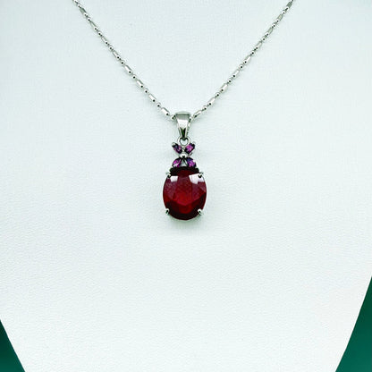 White gold plated silver pendant featuring a 7.87 ct ruby and 0.33 ct rhodolite garnets; elegant red and pink gemstone design.
