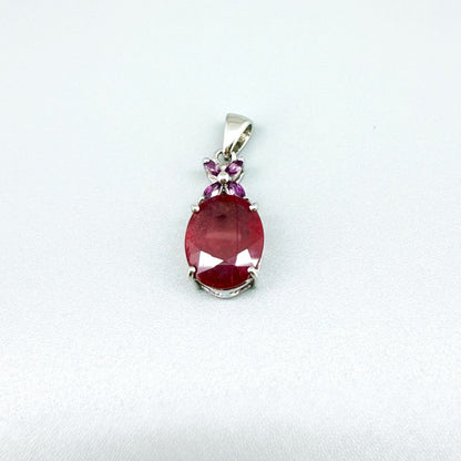 White gold plated silver pendant featuring a 7.87 ct ruby and 0.33 ct rhodolite garnets; elegant red and pink gemstone design.